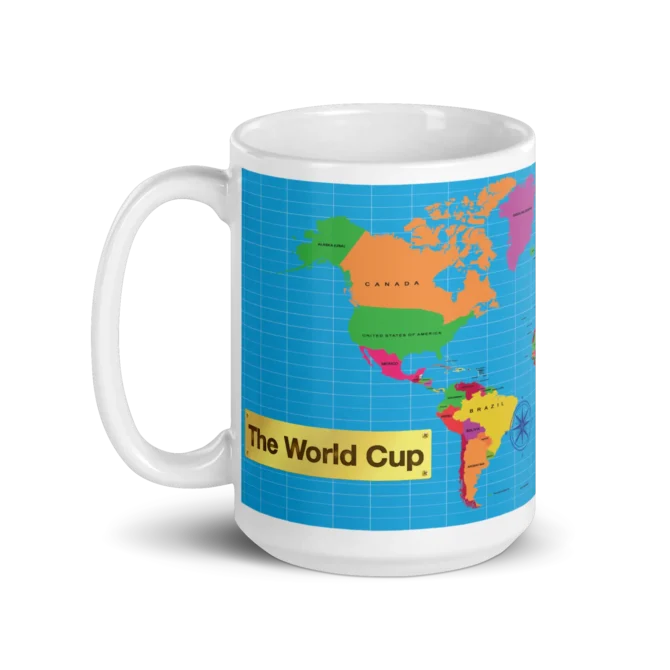 Taza The World Cup de cerámica con mapamundi y placa dorada vista frontal.