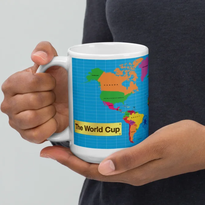 Mano mostrando la parte trasera de la taza The World Cup de cerámica.