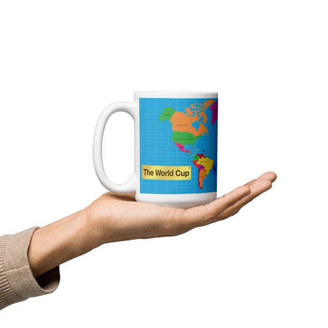 Persona sosteniendo la taza The World Cup de cerámica con mapamundi.