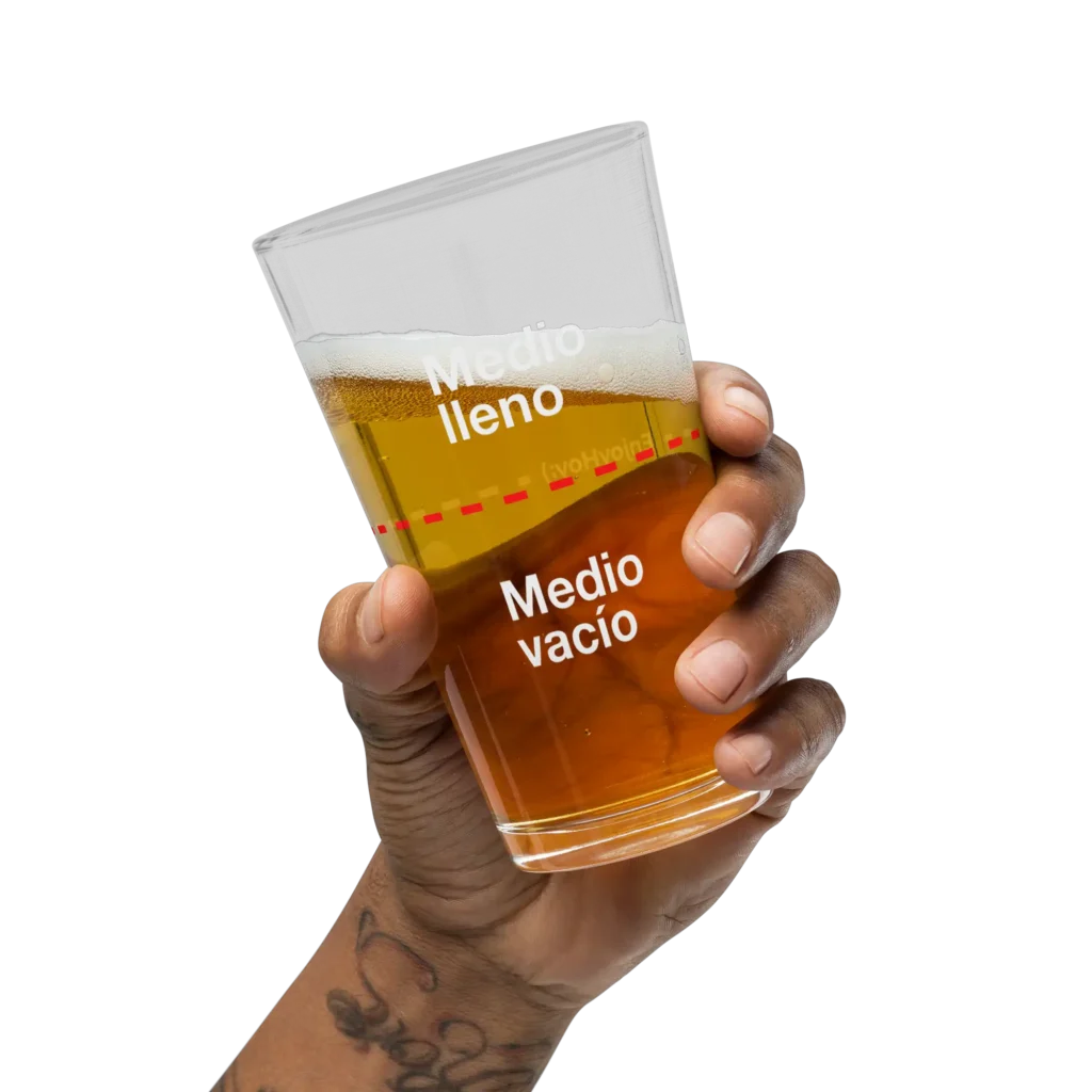 Mano tatuada levantando el vaso cervecero lleno de cerveza dorada en brindis