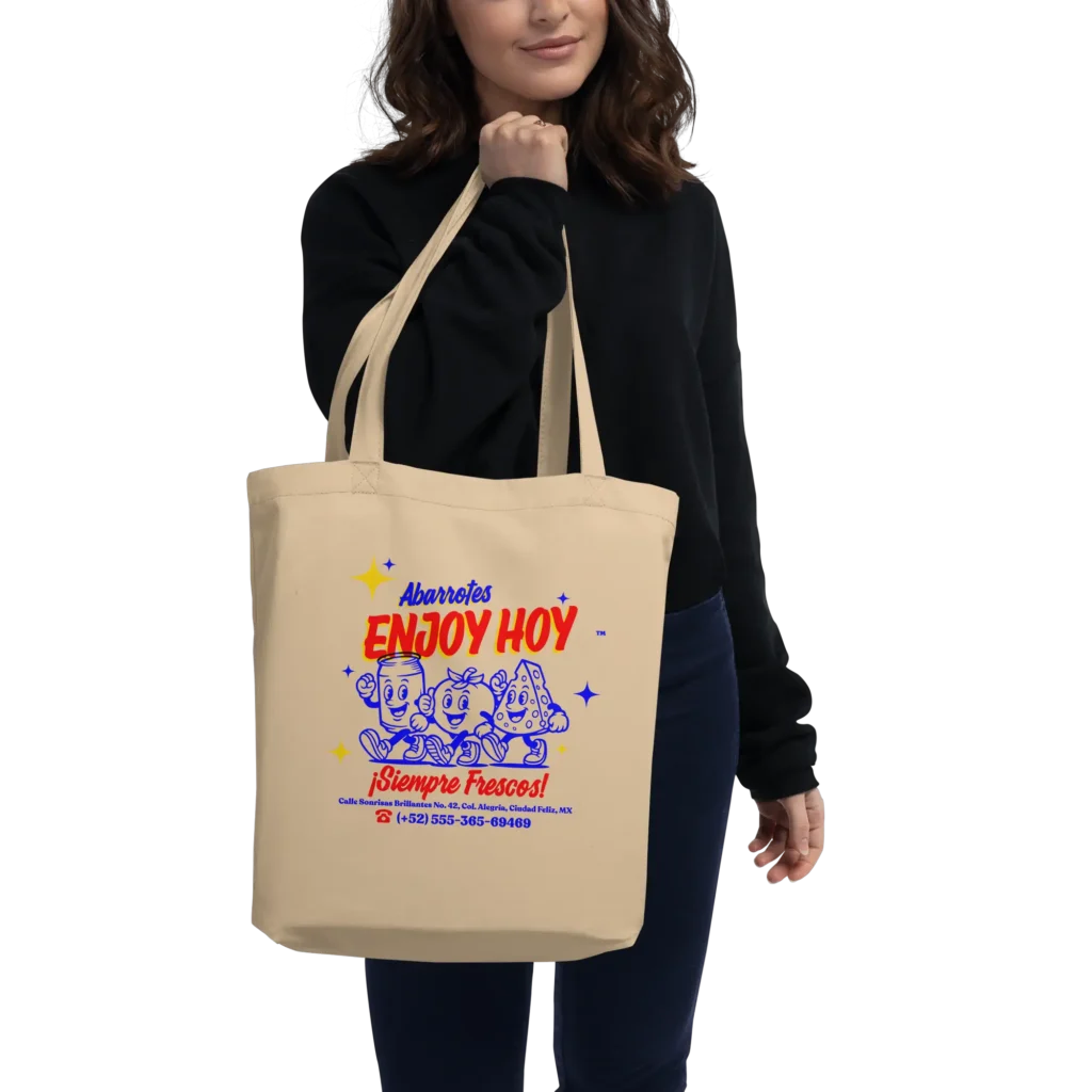 Mujer con suéter negro y jeans cargando la bolsa reutilizable de abarrotes al hombro