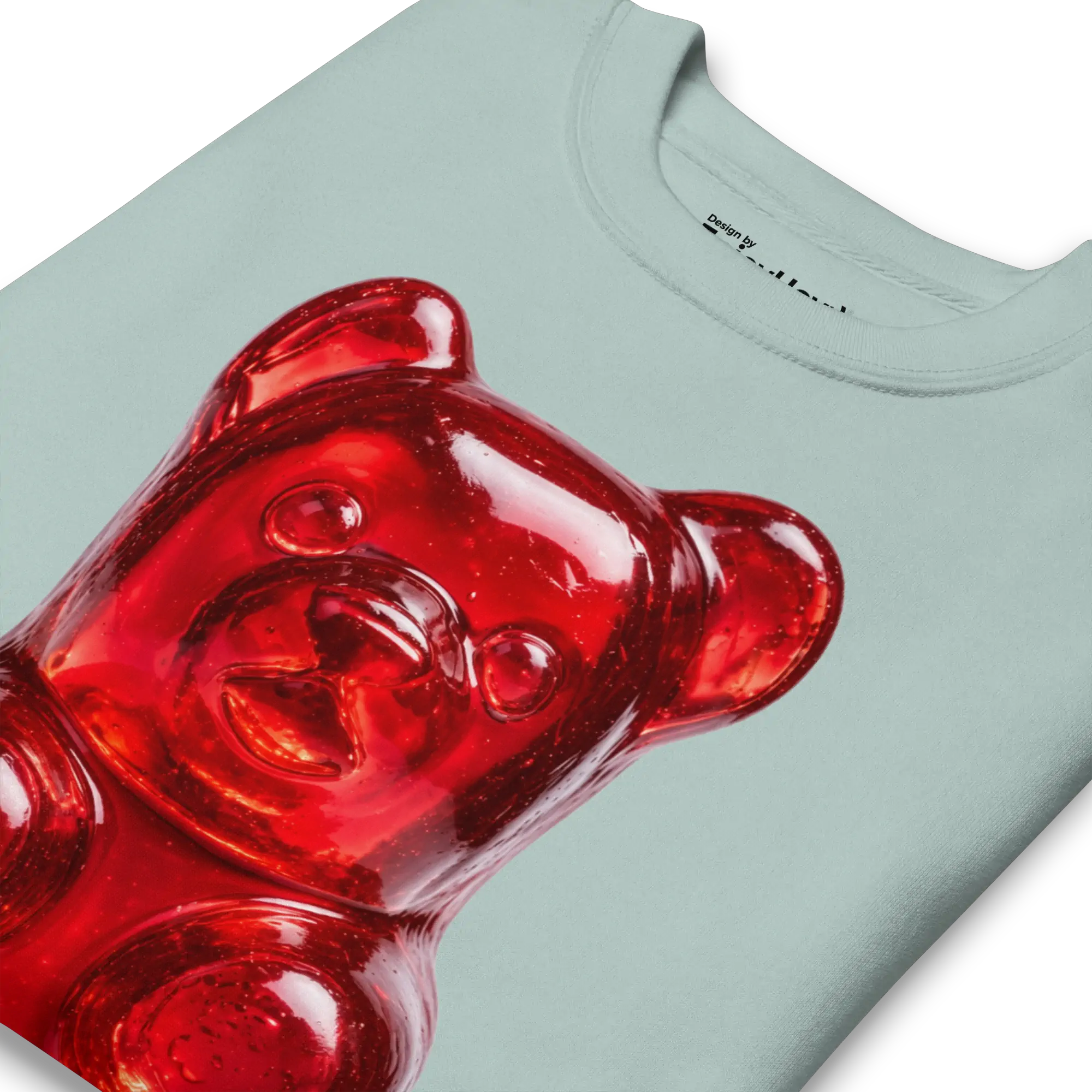 Acercamiento al osito de gomita rojo y brillante junto al cuello acanalado de la sudadera